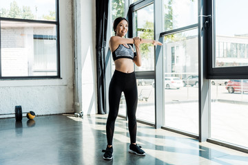 Obraz premium happy athletic girl in sportswear exercising in sports center