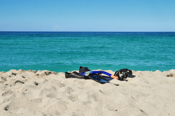 Fototapeta na wymiar snorkeling mask, flippers and breathing tube on the sand, on the ocean