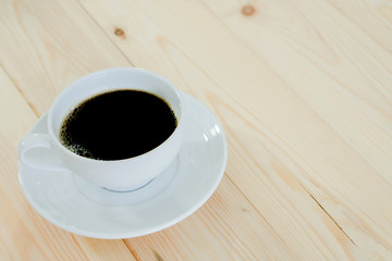 Black coffee cup on wood background