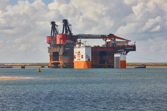 PORT OF ROTTERDAM, THE NETHERLANDS - SEPTEMBER 15, 2017: Heerema Hermod crane vessel being loaded on Dockwise Vanguard for shipping to China for recycling after 40 years of service