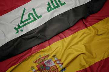 waving colorful flag of spain and national flag of iraq.