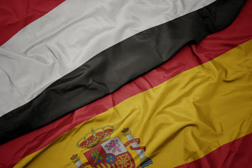 waving colorful flag of spain and national flag of yemen.