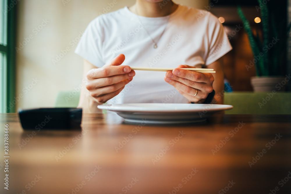 Wall mural close-up of female hands holding chopsticks