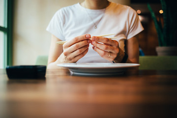 Young woman adjusts chopsticks