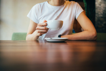Close-up of female's hands holding cup of coffee