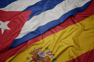 waving colorful flag of spain and national flag of cuba.