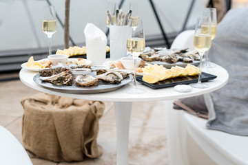 Opened oysters and lemon with white wine on the table. Restaurant delicacy, beautiful table...