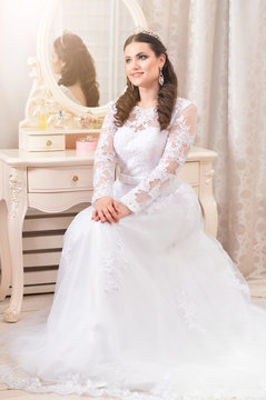 Portrait of young beautiful bride in white dress posing