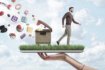 Side view of young man walking away from open dumpster and avalanche of waste in air, on grass-covered screen of digital tablet in woman's hand.