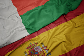 Fototapeta premium waving colorful flag of spain and national flag of madagascar.