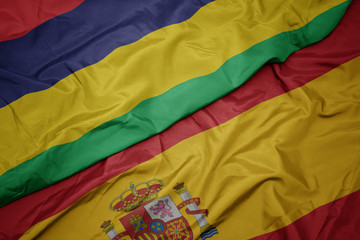 waving colorful flag of spain and national flag of mauritius.