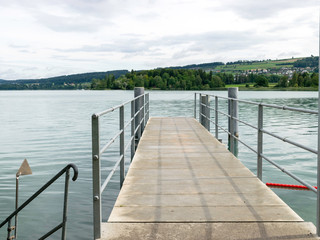 mall dock, calm and clear lake water, sky glare