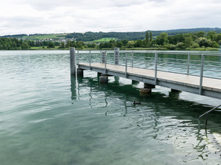 mall dock, calm and clear lake water, sky glare