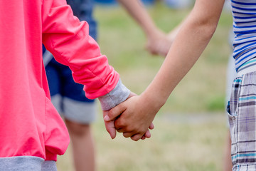 Boy and girl holding hands while playing. The concept of unity and trust_