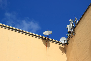 Telecommunication television parabolic antennas and Cellular phone antennas on the roof of a house....
