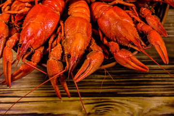 Plate with boiled crayfishes on wooden table