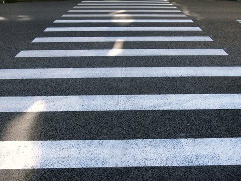   The pedestrian Zebra crossing across the asphalt road