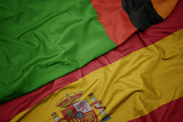 waving colorful flag of spain and national flag of zambia.