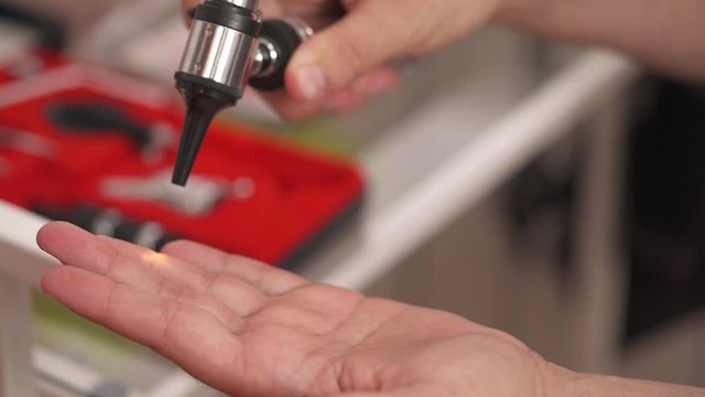 Close-up demonstration video of a professional therapist checking otoscope instrument before usage. Otolaryngology. selective focus shot