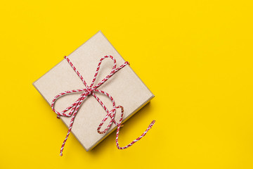 Gift box on yellow background top view, copy space for your text. Christmas or New Year concept.