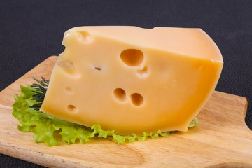 Maasdam cheese  in the board served salad leaves