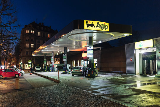 STRASBOURG, FRANCE - NOV 29, 2017: AGIP Gas station in France at night with people customers refueling cars and empty carwash nearby. Agip is part of the ENI Group