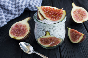 Pudding with chia and figs on the black wooden background. Closeup.