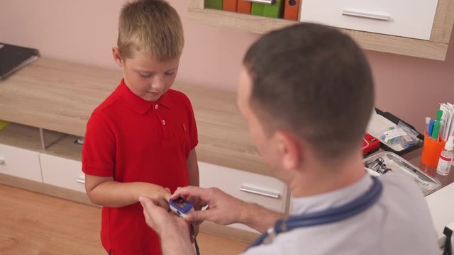 Pediatrician using finger pulse oximeter, monitoring vital sign. Medical concept