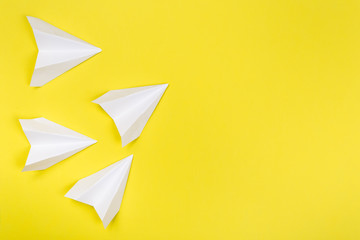 white paper airplane on yellow paper background