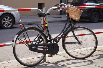 city bike with wicker basket is parked at the road, ecological mode of transport, sports lifestyle. convenient city