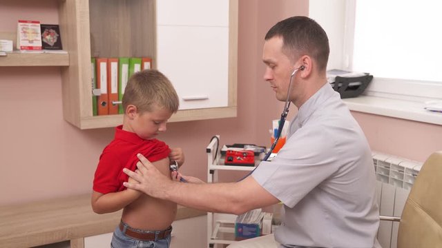 Young professional doctor examining patients lungs and breathing using stethoscope. Pediatric concept