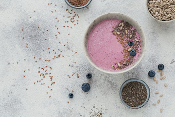 Obraz na płótnie Canvas Healthy breakfast with pink yogurt smoothie bowl made with berry and seeds