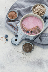 Pink yogurt smoothie bowl made with fresh blueberry and seeds