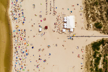 Aerial drone photography of the crowd of people on the beach. Sandy Baltic shore, northern Poland. 