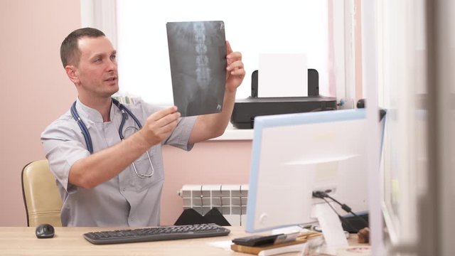 Close-up demonstration video of a professional vertebrologist examining spine X-ray. Lumbar vertebrae. Human anatomy