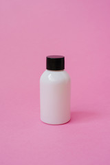 Realistic white cosmetic cream container. The layout of the bottle. Gel, balm and oil, without label for design on pink background