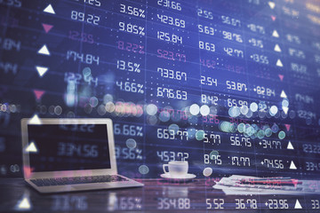 Stock market graph on background with desk and personal computer. Double exposure. Concept of financial analysis.