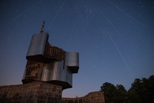 Perseids Meteor shower next to Monument to the uprising of the people in Petrova Gora in Croatia in dark night full of stars