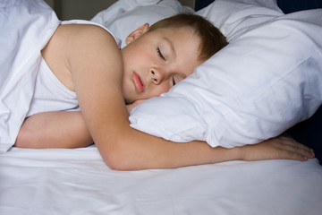 Fototapeta na wymiar Tired young boy sleeping in bedroom