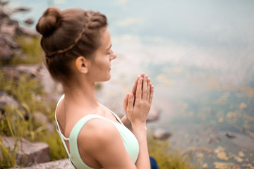 Thin brunette girl plays sports and performs beautiful and sophisticated yoga poses in a summer...