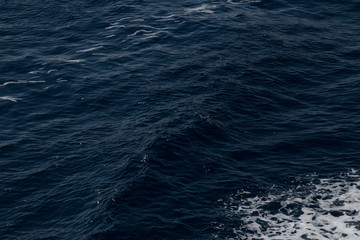 Dark sea water. Sea, wave, lights, reflect. Ruffle and foam on the sea. Dark with lights reflection water of the sea.