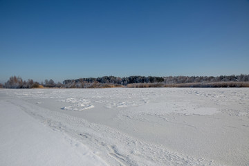 Fototapeta na wymiar winter landscape with lake and blue sky