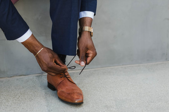 Hands tying shoe lace on man's oxford shoe