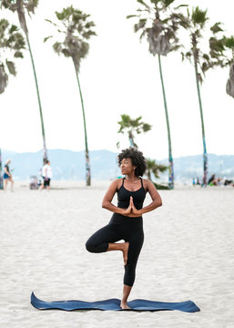 Profile of woman doing yoga pose on beach