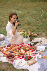 Young brunette woman enjoy outdoor picnic on green lawn