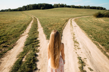 woman in front of two roads thinking deciding hoping for best taking chance