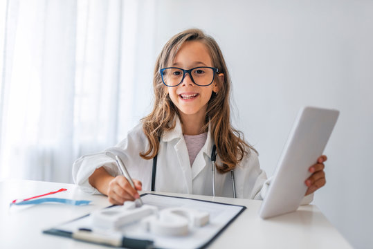 Child playing doctor with stethoscope in hands. Happy smiling kid girl playing at home or daycare. Education for preschool and kindergarten. Pediatric, healthcare and people concept.