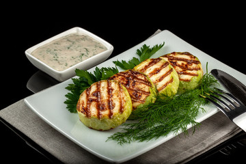Concept for a healthy summer diet: baked zucchini with dill sauce