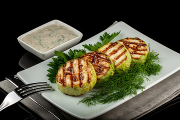 Concept for a healthy summer diet: baked zucchini with dill sauce