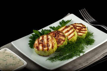 Concept for a healthy summer diet: baked zucchini with dill sauce